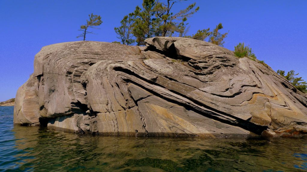 Corbeau du Nord<br /> Anticline and Syncline<br /> Syncline and anticline are terms used to describe folds based on the relative ages of folded rock layers. A syncline is a fold in which the youngest rocks occur in the core of a fold (i.e., closest to the fold axis), whereas the oldest rocks occur in the core of an anticline.<br /> Source:<br /> https://www.flickr.com/photos/phocoena/3795322402/in/gallery-wyojones-72157622540465016/<br /> --https://farm3.staticflickr.com/2485/3795322402_9a72d2754e_o_d.jpg<br /> --Parry-Sound-Ontario-Canada-Anticline-Syncline-3795322402_9a72d2754e_o_d.jpg